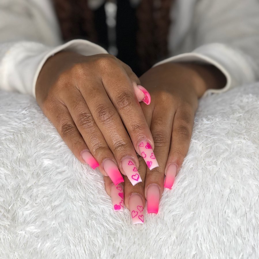 Classic Valentine’s Day nails featuring red and pink heart designs with a glossy finish for a romantic touch