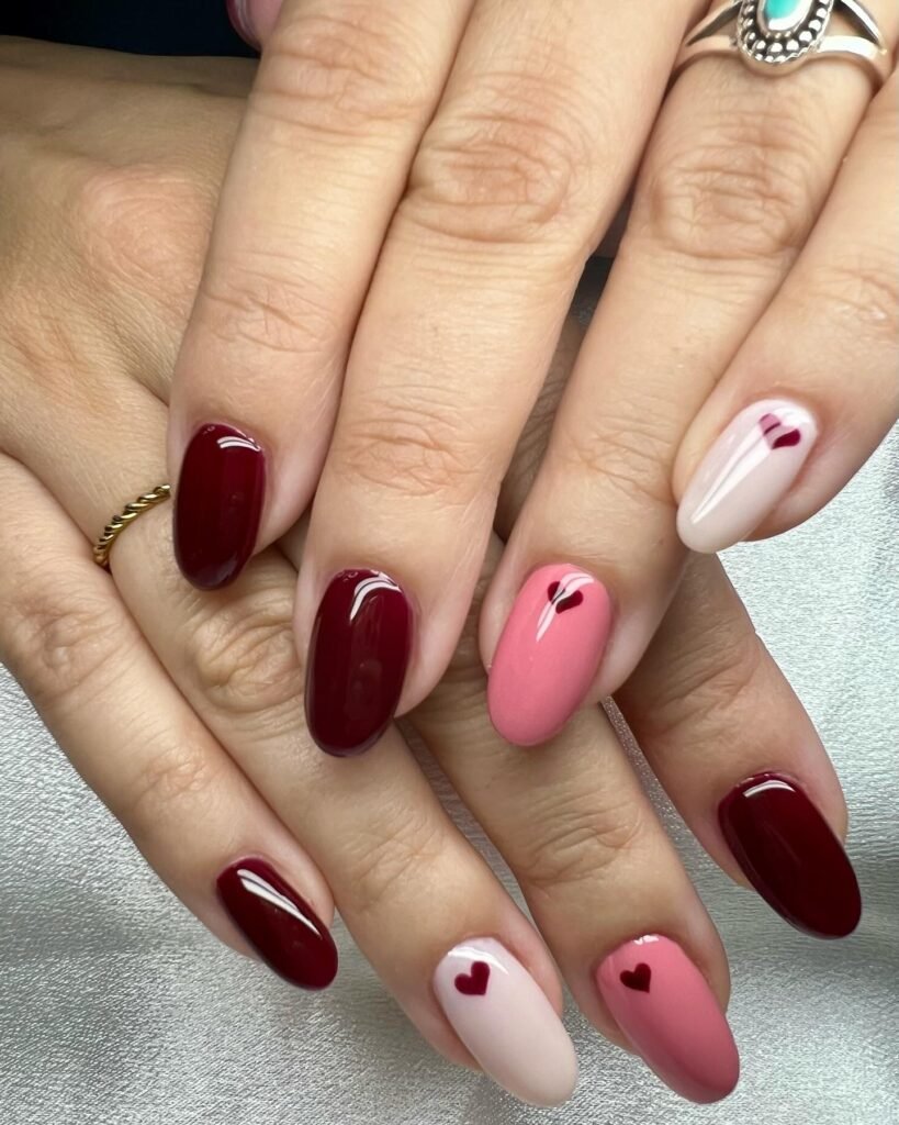 Classic Valentine’s Day nails featuring red and pink heart designs with a glossy finish for a romantic touch