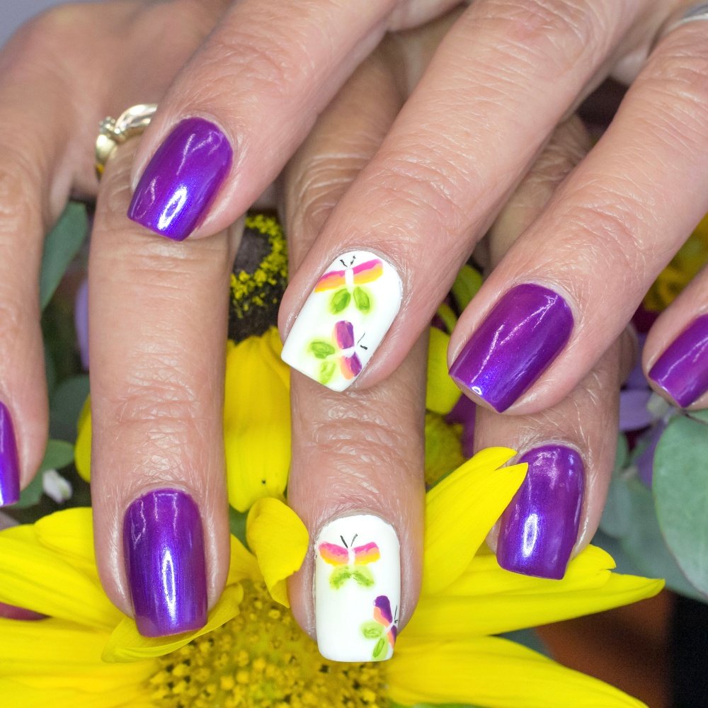 A stunning collection of butterfly nail art, showcasing pink, purple, and monarch designs on acrylic and press-on nails.