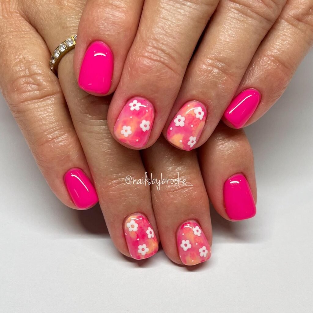 Elegant summer nails with vibrant pink and blue flower designs, featuring acrylic 3D flowers on a glossy white base, perfect for spring and summer fashion.