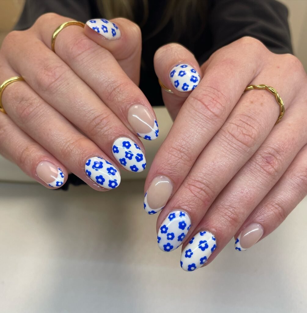 Elegant summer nails with vibrant pink and blue flower designs, featuring acrylic 3D flowers on a glossy white base, perfect for spring and summer fashion.